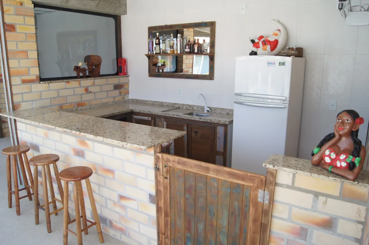 Área de convivência da Pousada Marluah com bar, bancada e cozinha