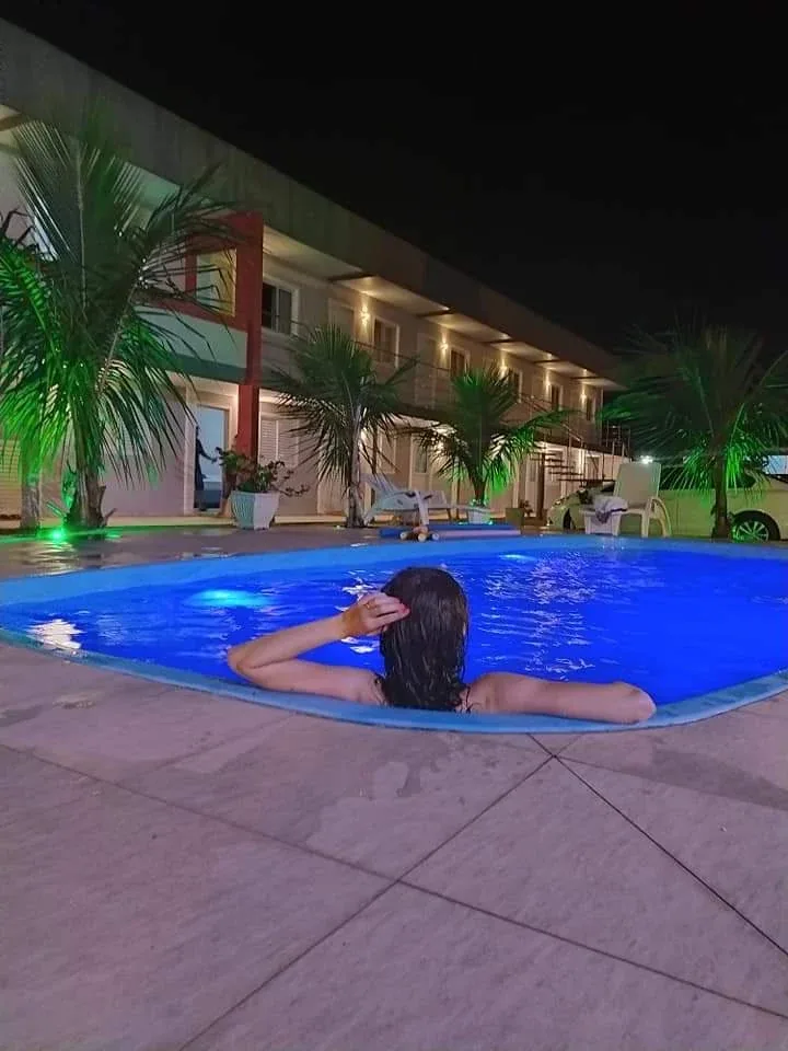 Piscina iluminada à noite na Pousada Marluah