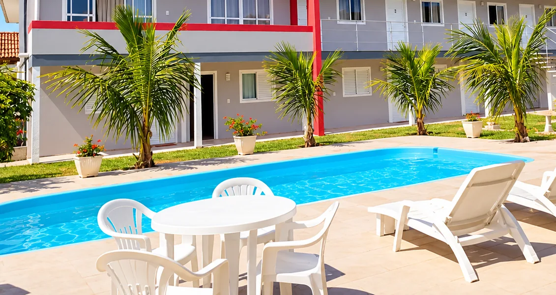 Piscina ao ar livre da Pousada Marluah na Pinheira, SC, com mesas e espreguiçadeiras